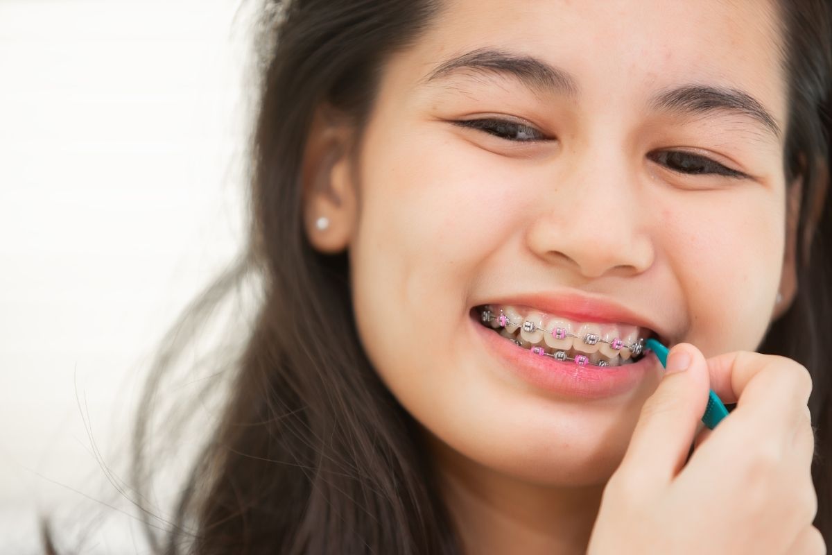 girl-using-brush-cleaning-braces-treatment-health